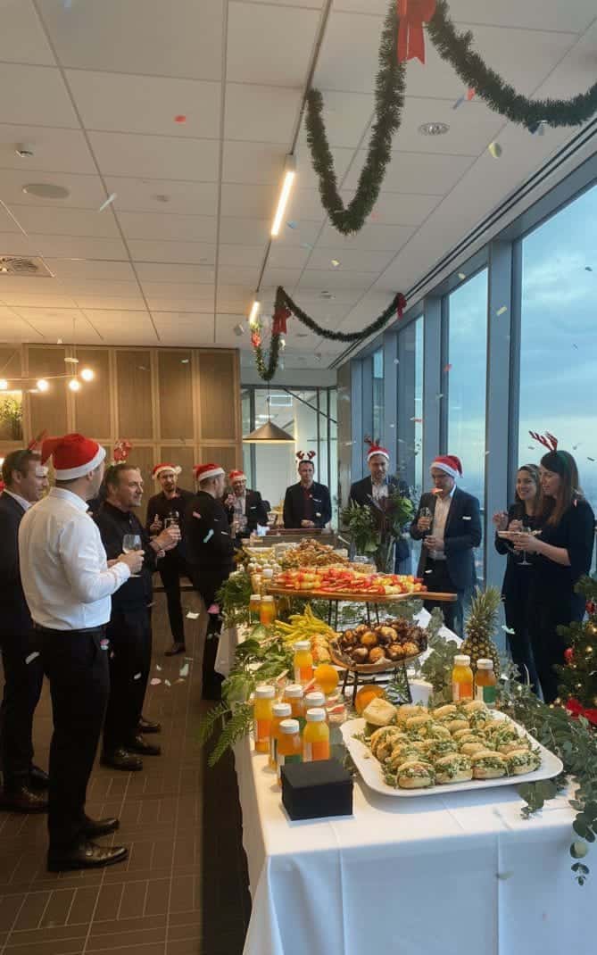 Festive holiday party with private chef service, holiday snacks, and Christmas decorations in a modern office setting.