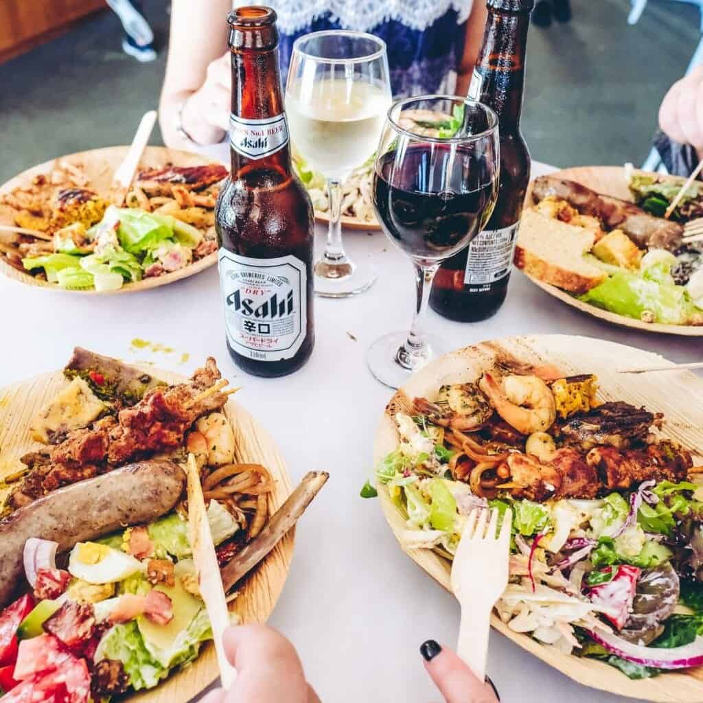 Grilled seafood and salads with drinks at a dining table, showcasing fresh ingredients and casual di.