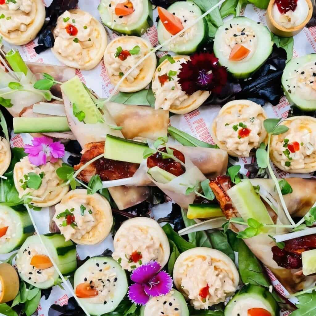 Miniature savory bites with cucumber, cream cheese, and decorative garnishes, perfect for elegant ev.