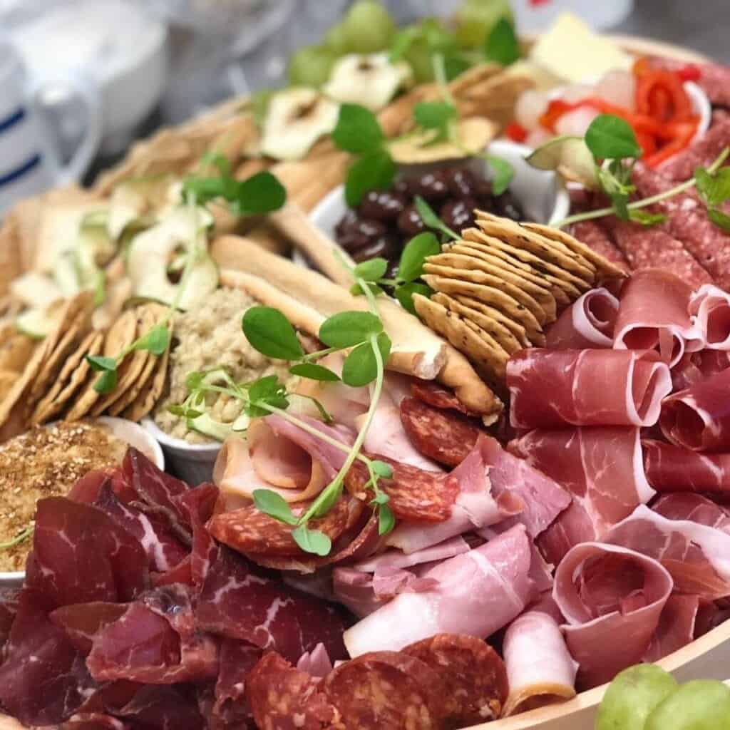 Succulent gourmet charcuterie platter with cured meats, cheeses, olives, and fresh herbs for private.