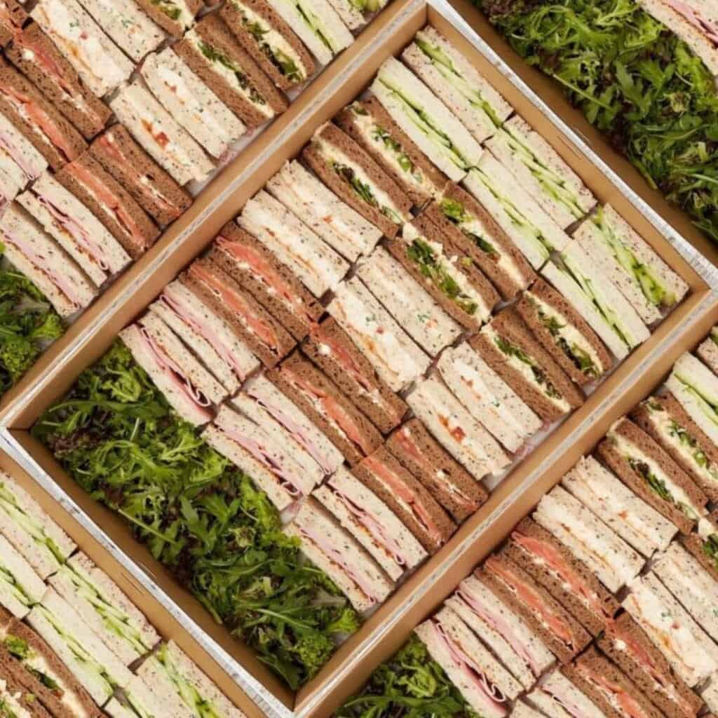 Egg sandwiches platter with fresh greens, perfect for catering or events.