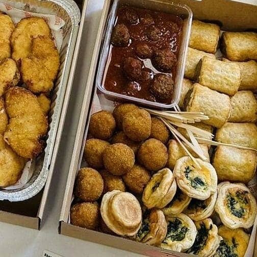 Fried appetizers with dipping sauce and vegetable rolls, ready for catering or private event.